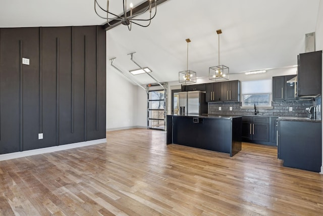 kitchen featuring a center island, a healthy amount of sunlight, stainless steel fridge, and decorative backsplash