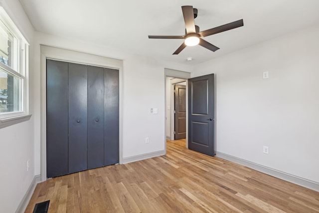 unfurnished bedroom with light wood finished floors, a closet, visible vents, ceiling fan, and baseboards