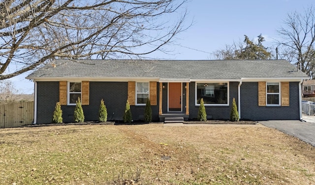 ranch-style house with brick siding, a front lawn, and fence