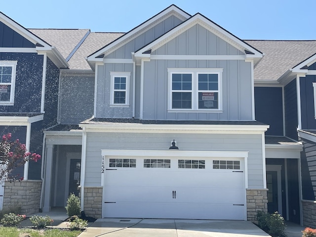 craftsman house featuring driveway, stone siding, an attached garage, and board and batten siding