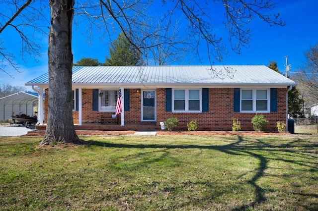 ranch-style home featuring a carport, brick siding, metal roof, and a front lawn