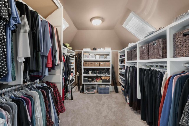 walk in closet with lofted ceiling and carpet