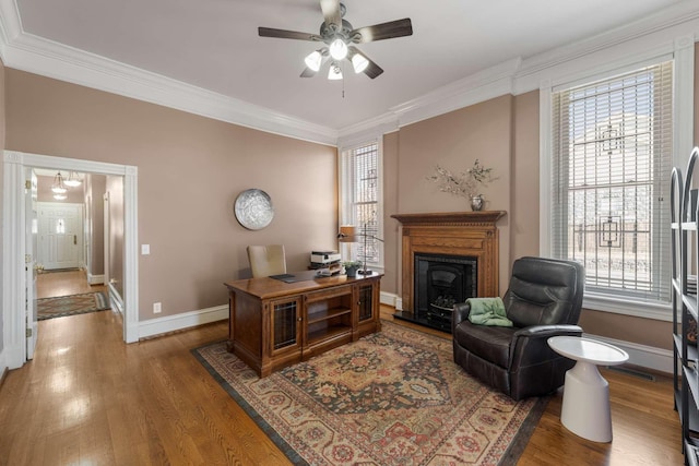 office featuring crown molding, baseboards, ceiling fan, and wood finished floors