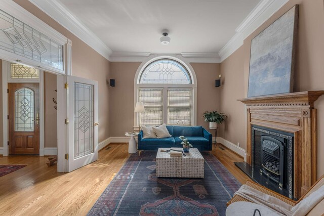 living area featuring ornamental molding, wood finished floors, and baseboards