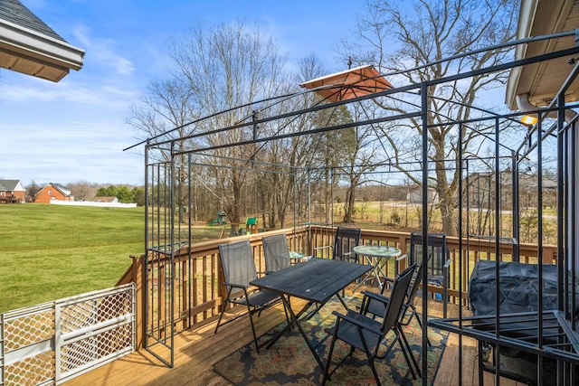 deck featuring outdoor dining space and a yard