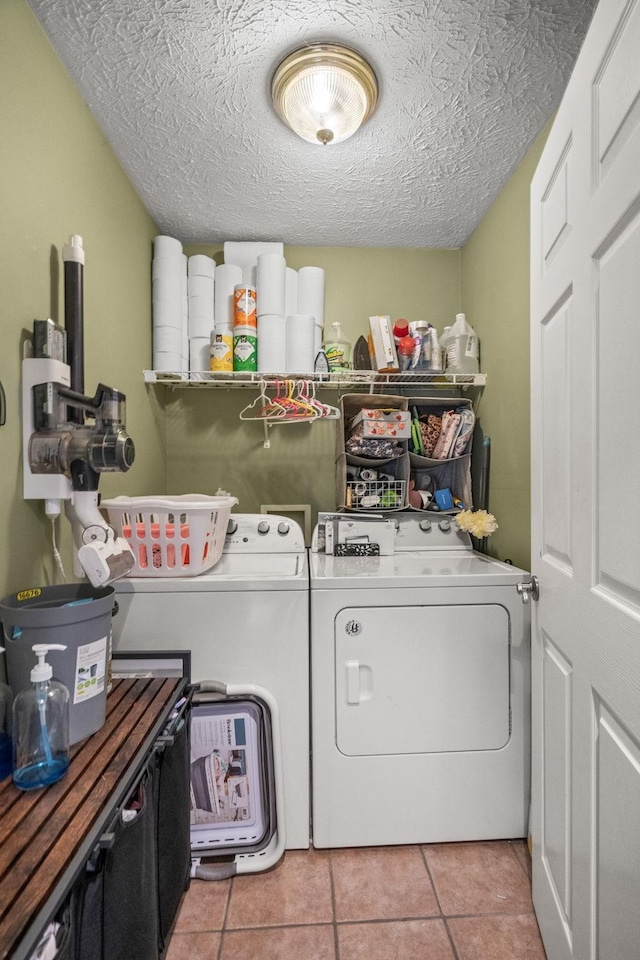 laundry room with a textured ceiling, laundry area, separate washer and dryer, and tile patterned floors