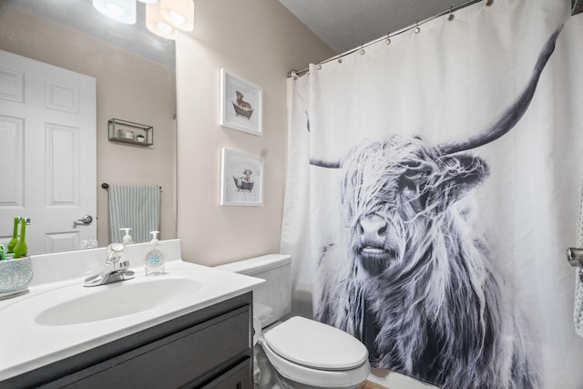 full bathroom featuring a shower with shower curtain, vanity, and toilet