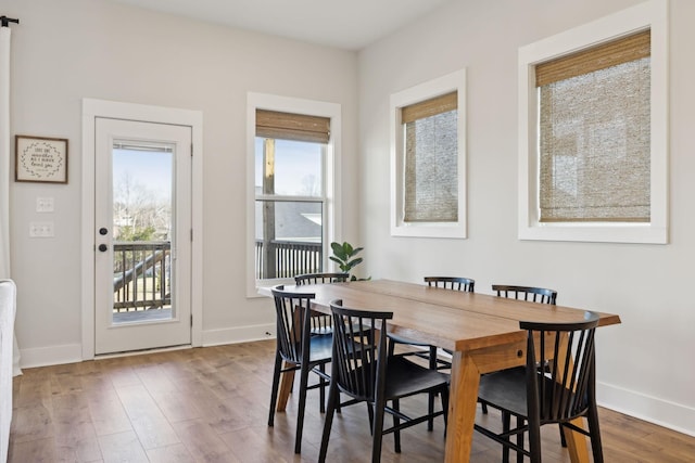 dining space with baseboards and wood finished floors