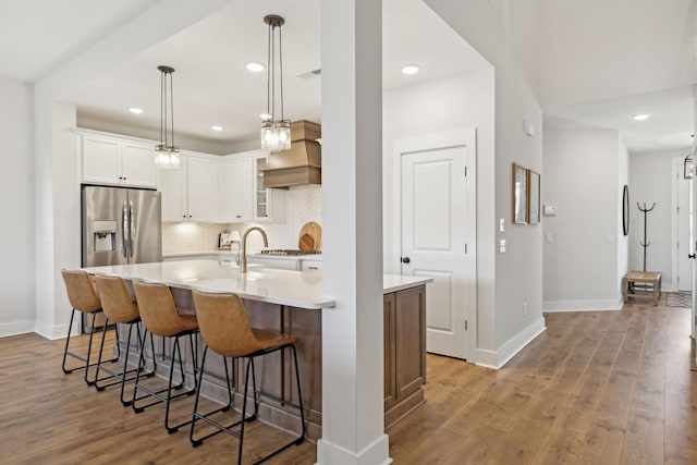 kitchen featuring light countertops, white cabinets, backsplash, and wood finished floors