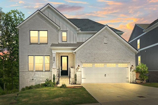 view of front facade with brick siding, concrete driveway, an attached garage, board and batten siding, and a front yard