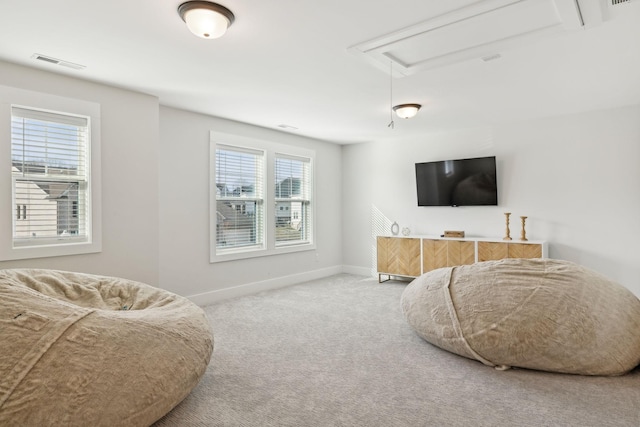 carpeted living area featuring visible vents, attic access, and baseboards