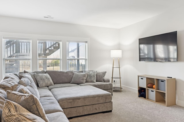 living room featuring carpet, visible vents, and baseboards