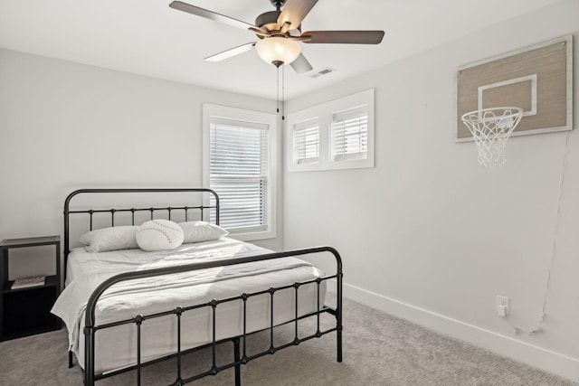 carpeted bedroom with visible vents, baseboards, and a ceiling fan