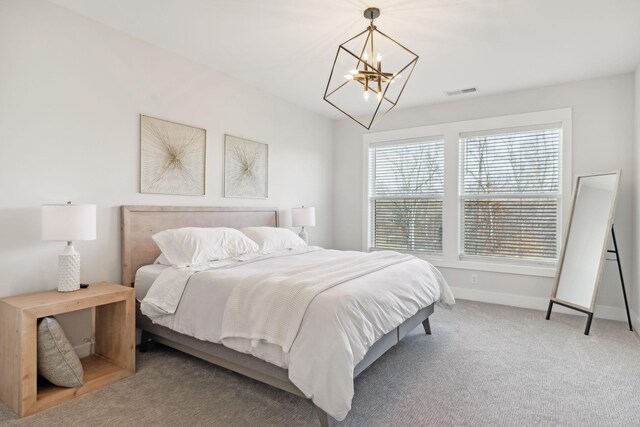 bedroom with carpet floors, visible vents, baseboards, and an inviting chandelier