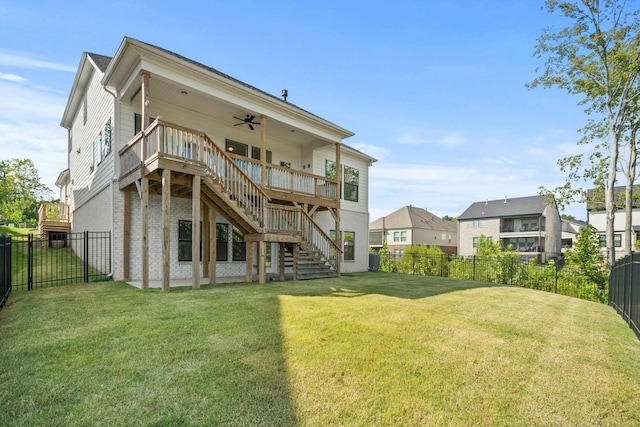 rear view of house with a fenced backyard, brick siding, stairway, a lawn, and a wooden deck