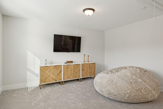 living area featuring carpet and baseboards