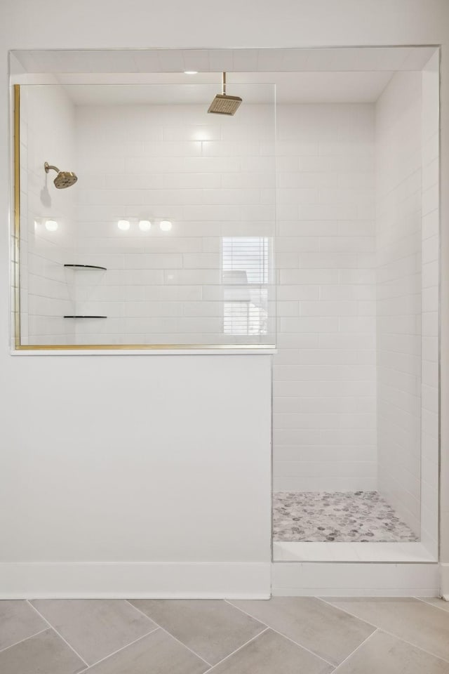 bathroom featuring tile patterned flooring, baseboards, and a walk in shower