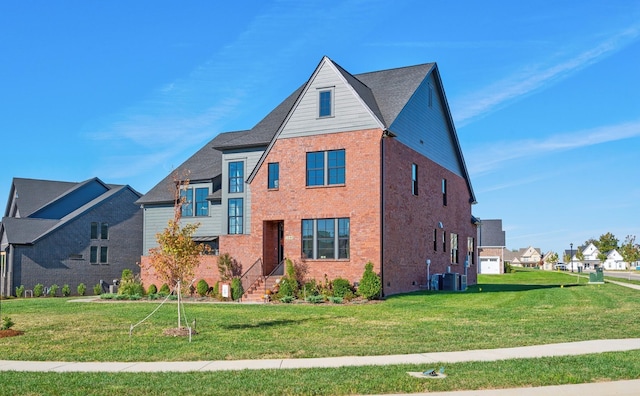 view of front facade with central AC, brick siding, and a front yard