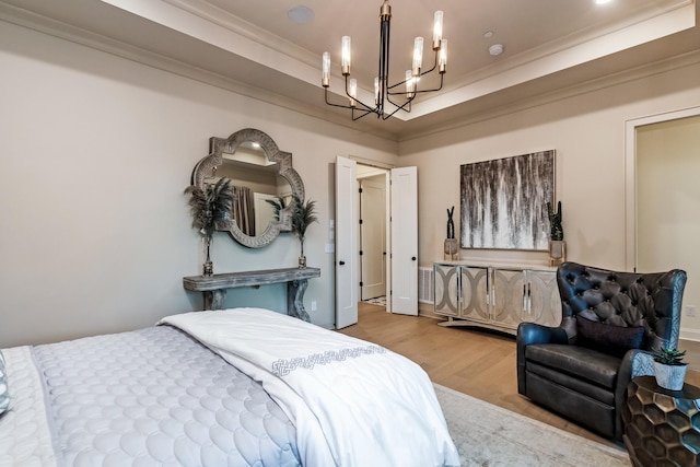 bedroom featuring a raised ceiling, a notable chandelier, crown molding, and wood finished floors