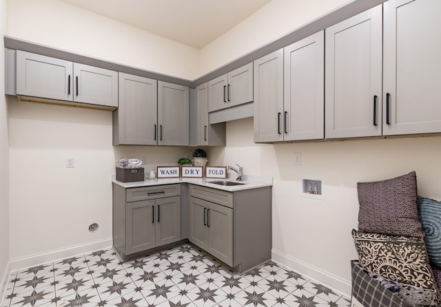 kitchen featuring a sink, light floors, and gray cabinets