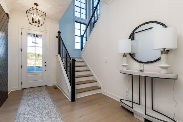 entrance foyer with stairway, baseboards, and wood finished floors