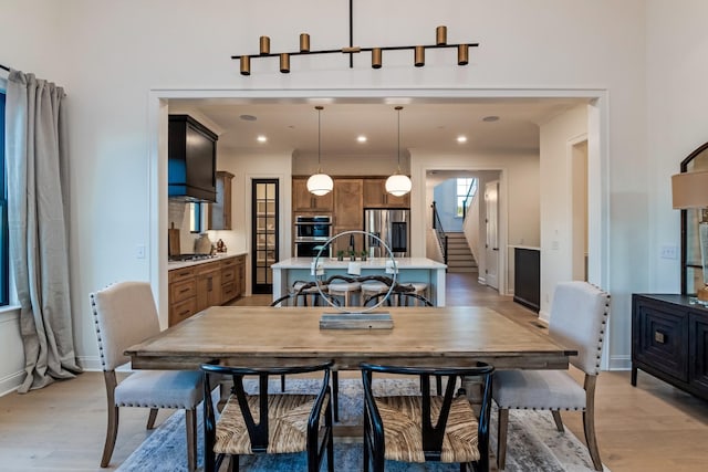 dining room with light wood-style floors, recessed lighting, stairway, and baseboards