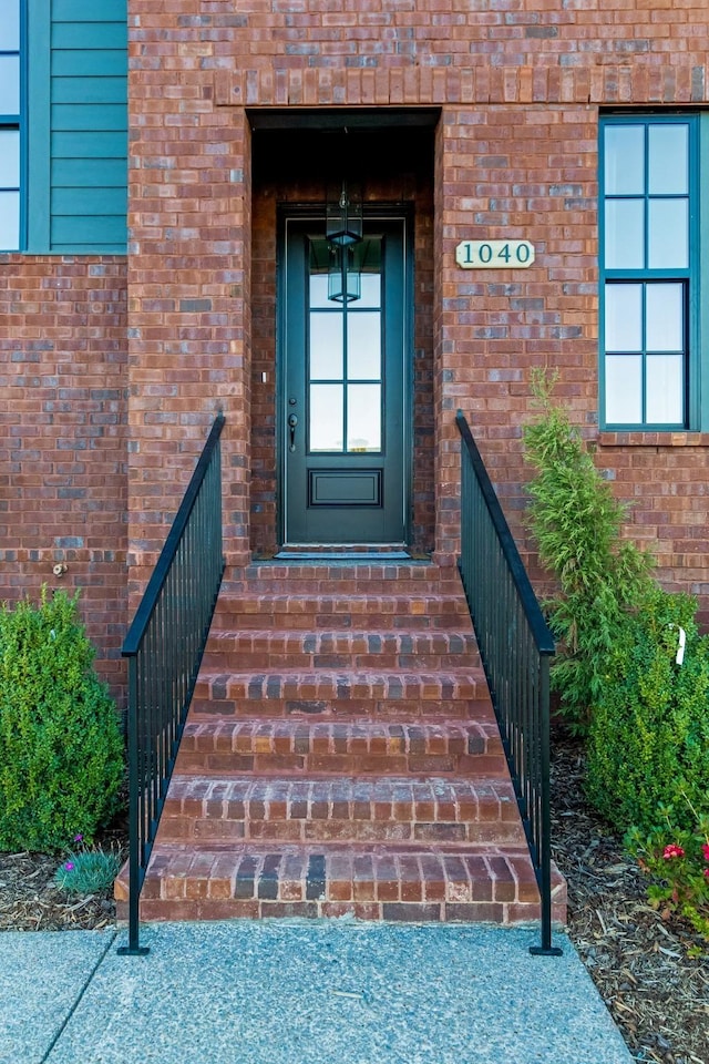 entrance to property featuring brick siding