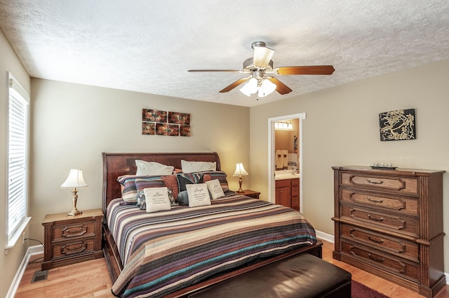 bedroom with light wood-style floors, multiple windows, visible vents, and a textured ceiling