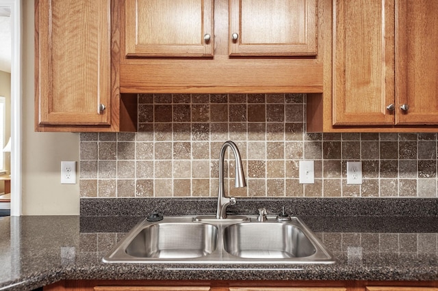 kitchen with brown cabinets, a sink, and decorative backsplash