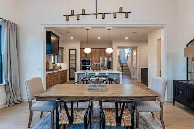 dining area with light wood-style floors, baseboards, stairway, and recessed lighting