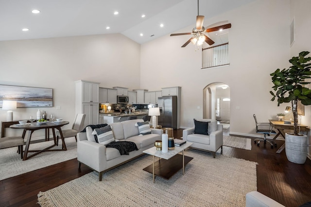 living area featuring arched walkways, ceiling fan, wood finished floors, and recessed lighting