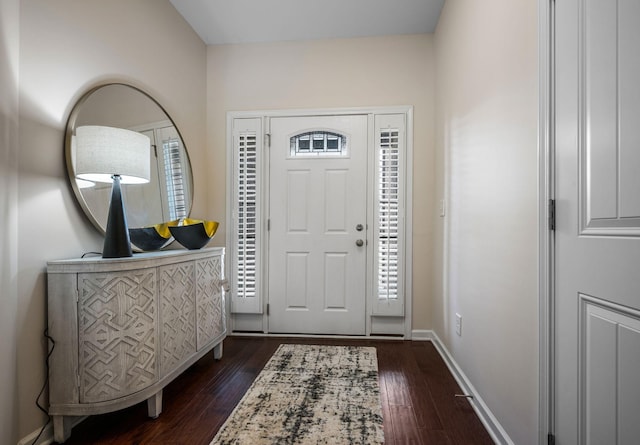 entrance foyer featuring dark wood finished floors and baseboards