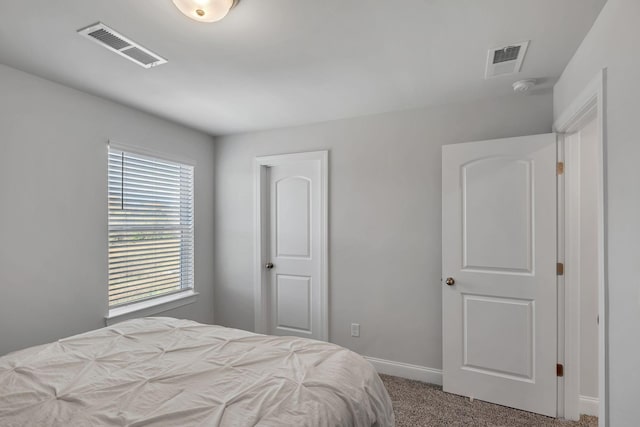 carpeted bedroom with visible vents and baseboards