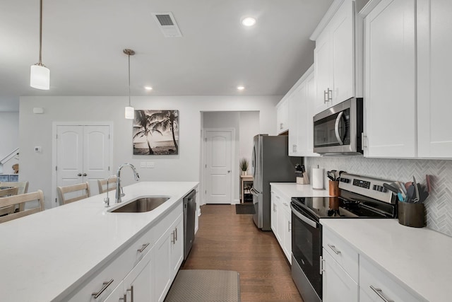 kitchen featuring white cabinets, stainless steel appliances, a sink, and light countertops