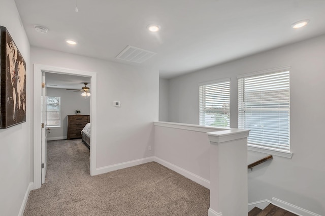 hallway with recessed lighting, light carpet, visible vents, an upstairs landing, and baseboards