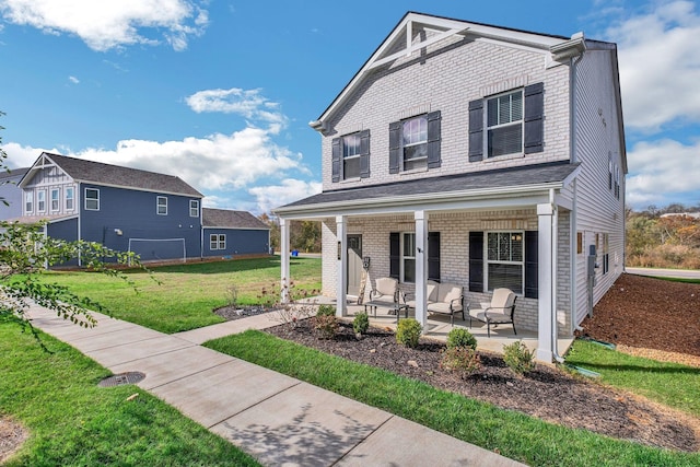 view of front of property featuring a porch, a front yard, and brick siding