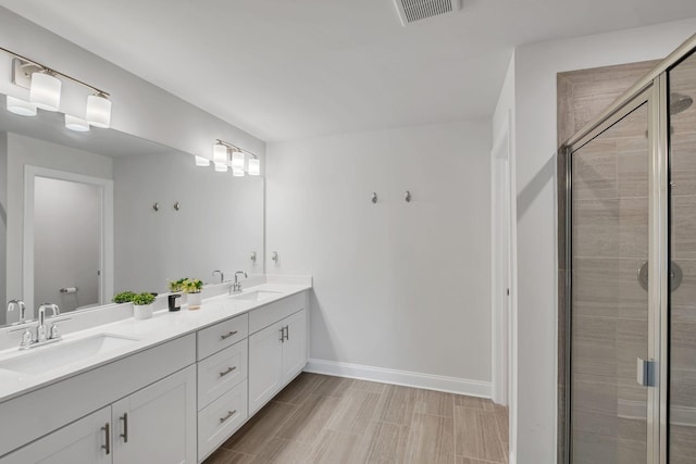 full bathroom with baseboards, a sink, visible vents, and a shower stall