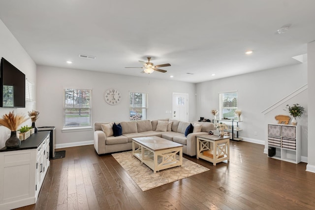 living area with plenty of natural light, visible vents, dark wood finished floors, and baseboards