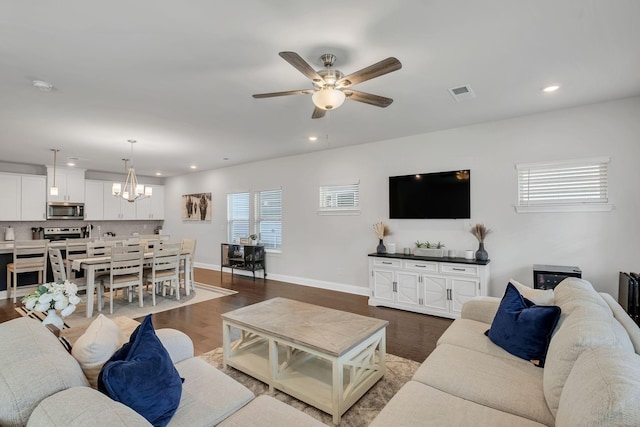 living room with baseboards, dark wood-type flooring, visible vents, and recessed lighting