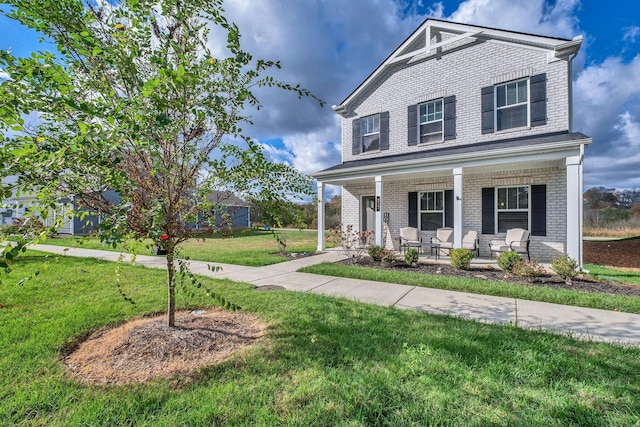 view of front of house with a porch, a front yard, and brick siding