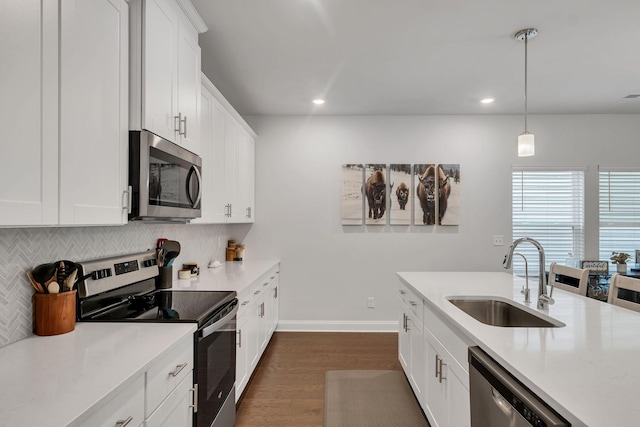 kitchen with light countertops, appliances with stainless steel finishes, backsplash, and a sink