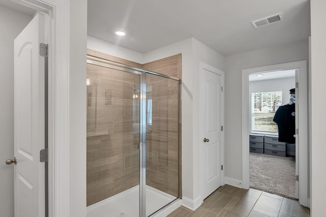 full bath featuring a stall shower, visible vents, and baseboards