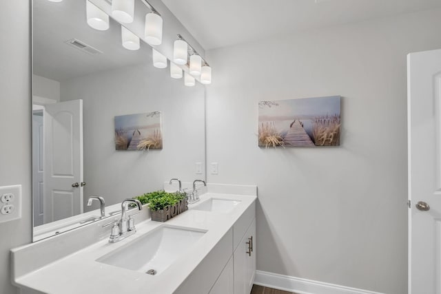 bathroom with visible vents, a sink, baseboards, and double vanity