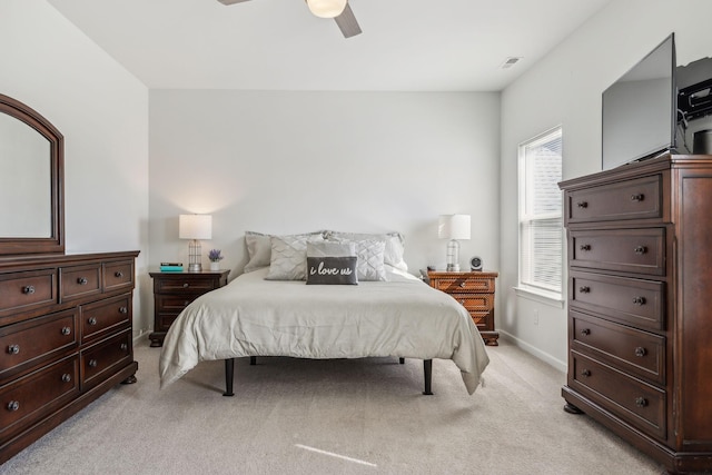 bedroom with light carpet, ceiling fan, and baseboards