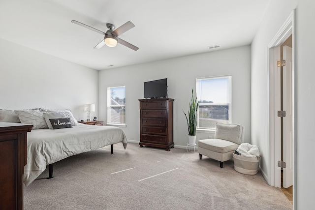 bedroom featuring baseboards, a ceiling fan, visible vents, and light colored carpet