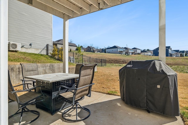 view of patio with outdoor dining area, area for grilling, fence, a residential view, and ac unit