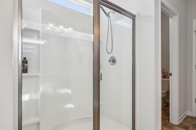 bathroom featuring toilet and a stall shower