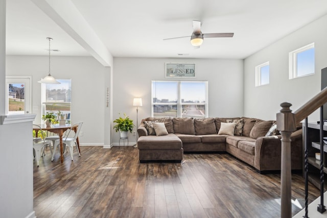 living room featuring dark wood finished floors, visible vents, a ceiling fan, baseboards, and stairs