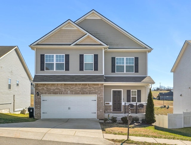 craftsman house featuring a porch, a garage, brick siding, fence, and concrete driveway