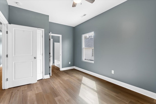 unfurnished bedroom with a ceiling fan, visible vents, baseboards, and wood finished floors